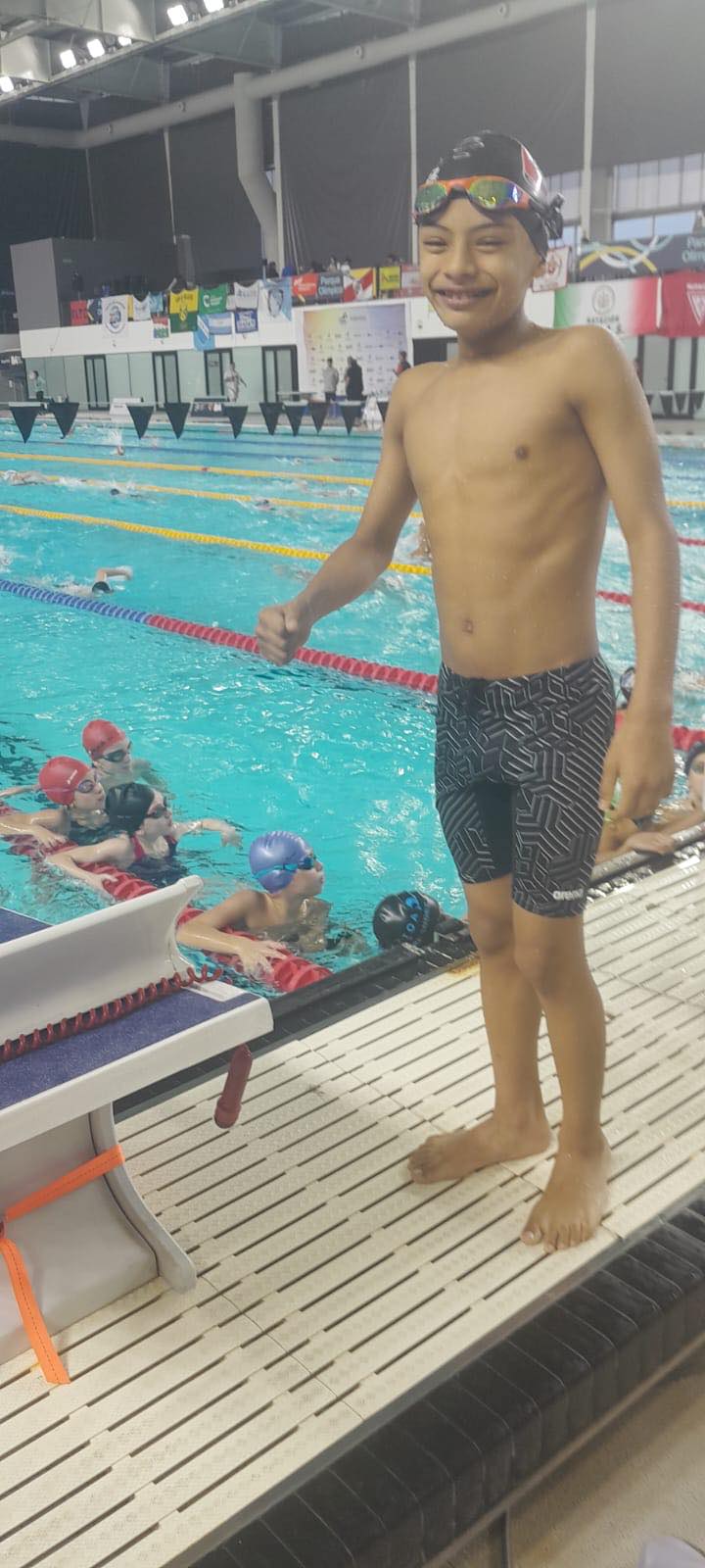 Benjamín al borde de la pileta en el Complejo Acuático del Parque Roca, con el puño en alto tras competir en el Nacional