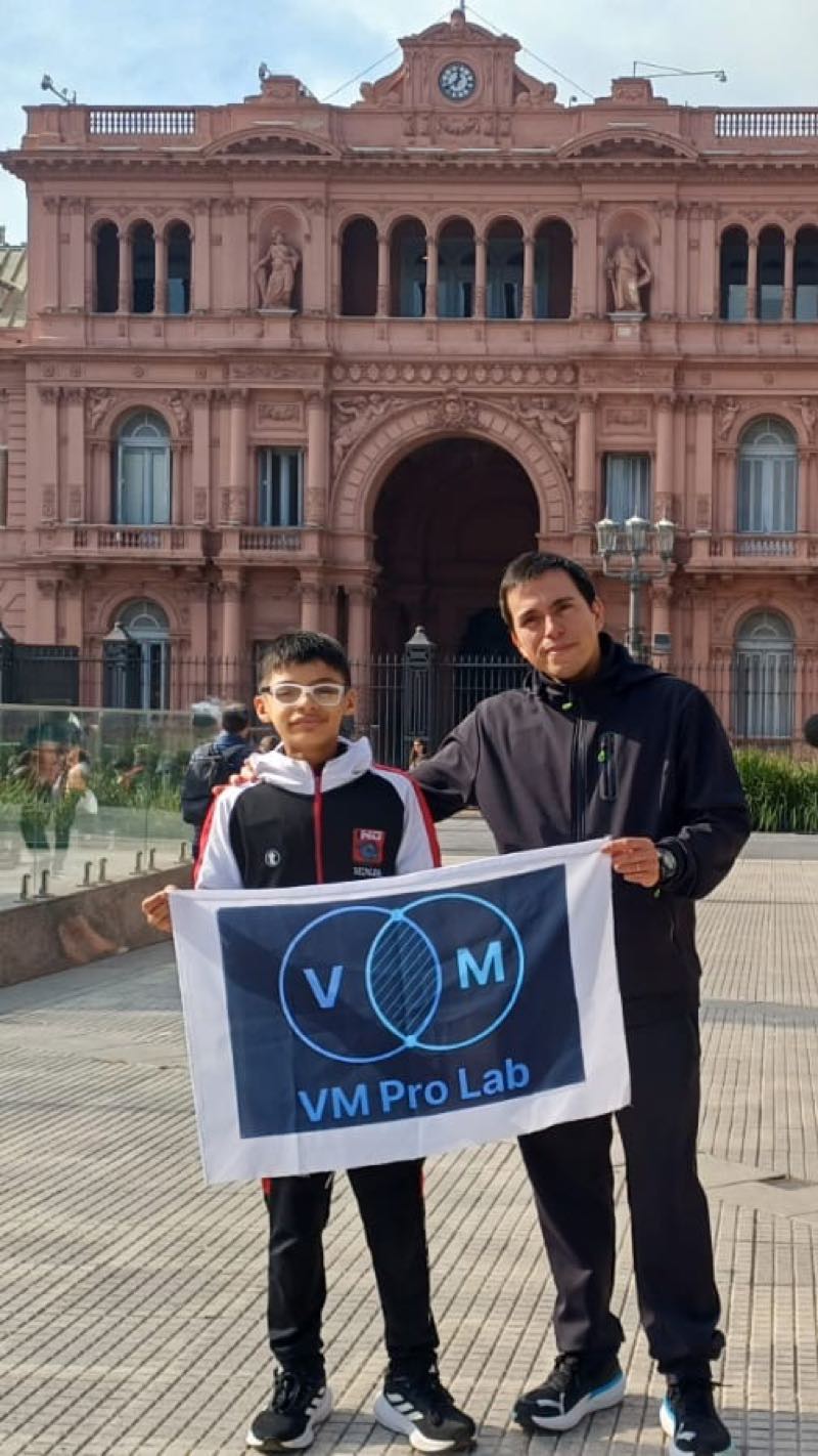 Benjamín y su entrenador con la bandera de VM Pro Lab, sponsor tecnológico, frente a la Casa Rosada en Buenos Aires