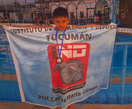 Benjamín con la bandera del IND Tucumán y medalla en su debut